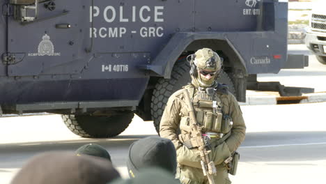 Policía-Armado-Parado-Cerca-De-Un-Vehículo-Blindado-En-La-Frontera-Entre-Estados-Unidos-Y-Canadá-Durante-La-Protesta-Del-Convoy-De-La-Libertad-En-Windsor,-Ontario,-Canadá