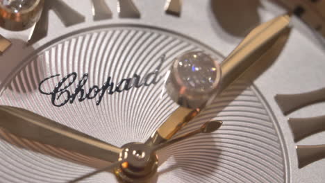 Sparkling-diamonds-floating-inside-luxury-Chopard-watch-gold-dial-face,-macro-shot