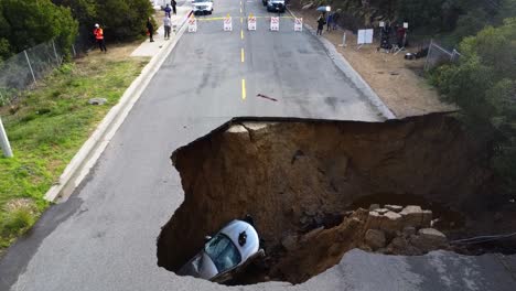 Aerial-view-towards-a-car-in-a-sinkhole,-sunny-day-in-Los-Angeles,-USA
