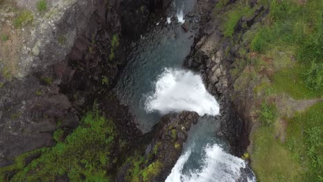 Aerial-flyover-idyllic-landscape-with-stream-and-waterfall-in-Iceland,Europe
