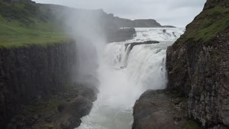 Aerial-flight-towards-Dettifoss-Waterfall-crashing-down-with-spraying-water-in-Iceland