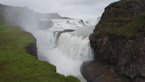 Misty-powerful-waterfall-of-Dettifoss-in-Iceland,-aerial-fly-backward-view
