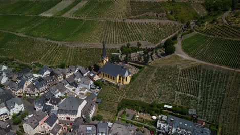 Camera-panning-at-a-church-in-the-middle-of-a-village-and-a-vineyard
