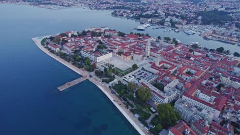 Medieval-city-center-of-Zadar-with-old-square,-blue-hour,-aerial