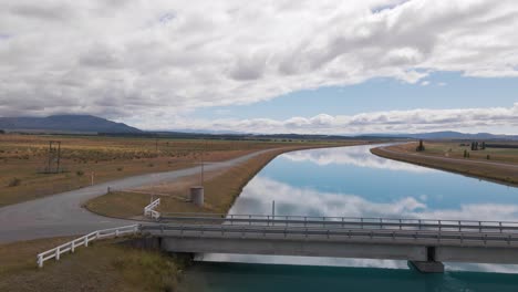 Narrow-bridge-connecting-the-two-banks-of-the-picturesque-Pukaki-Canal-in-New-Zealand