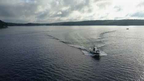 Luftumlaufbahnen-Motorboot-Auf-Sommersee-Mit-Wake-Boarder-Surfen