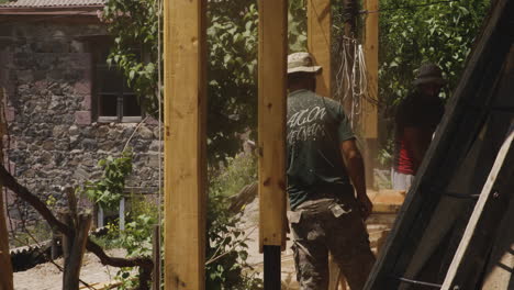 Dos-Trabajadores-Construyendo-Una-Casa-Terraza-Con-Pilares-De-Madera-En-Georgia