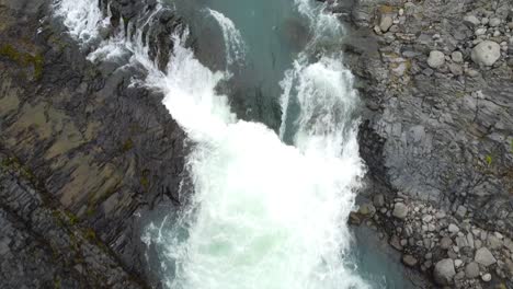 Blaues-Flusswasser-Und-Mächtiger-Strom-Des-Felsigen-Tals-In-Island,-Luftaufnahme-Von-Oben-Nach-Unten