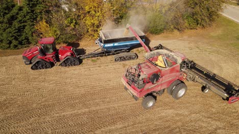 Case-8120-Harvester-Entleert-Den-Korntank-In-Den-Kinze-1051-Anhänger,-Der-An-Case-Quadtrac-600-Befestigt-Ist