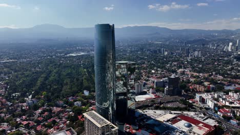 Aerial-view-rotating-towards-the-reflecting-Torre-Mítikah-tower,-in-Mexico-city