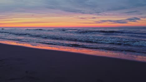 Verträumte-Meereslandschaft,-Niedrige-Luftdrohne-Fliegt-Bei-Sonnenuntergang-über-Wellen,-Orange-violetter-Himmel