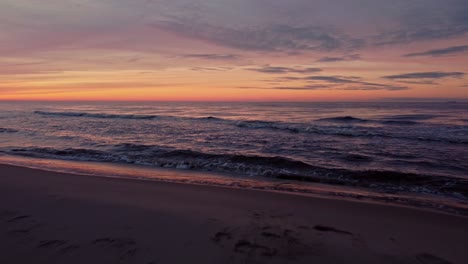 Dramatischer-Sonnenuntergang-über-Dem-Meer-In-Einem-Aufschlussreichen-Strand-Aus-Der-Luft