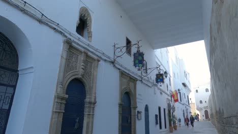 Pan-Hacia-Abajo-Desde-El-Techo-De-La-Calle-Con-Triciclo-Azul-Acercándose-Y-Pasando-En-Tánger,-Medina