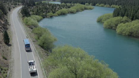 AERIAL---Bus-on-highway-next-to-Limay-River-in-Valle-Encantado,-Patagonia,-Argentina
