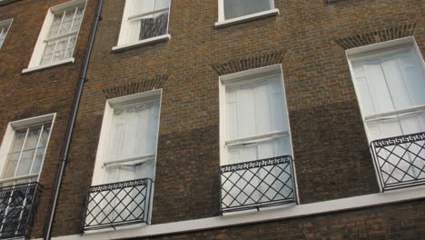 Tilt-Down-Revealing-Shot-Of-Red-Door-Of-Charles-Dickens-Museum-In-London,-UK