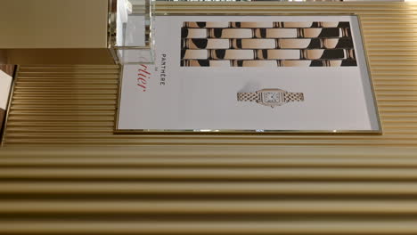 Luxusgeschäft-Für-Cartier-Uhren-Mit-Logo-Marke-An-Der-Wand,-Vertikale-Zeitlupenansicht