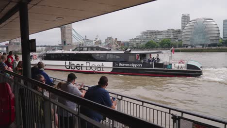 Esperando-A-Los-Pasajeros-En-El-Muelle-Con-El-Barco-Uber-Que-Llega-Al-Río-Támesis-En-Londres,-Reino-Unido