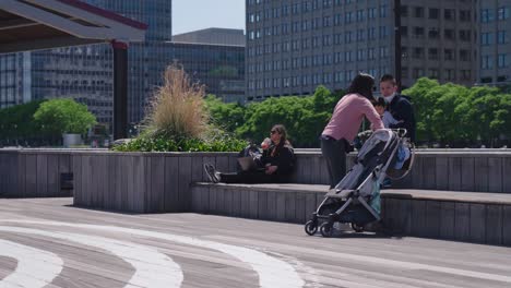 Happy-Asian-Family-Enjoying-The-Morning-Sitting-On-Concrete-Bench-Outside-The-Building