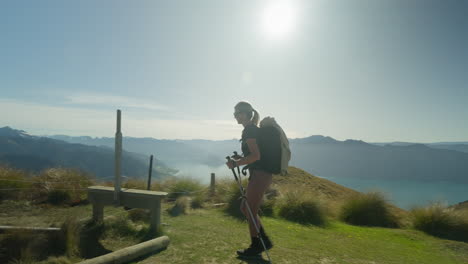 Excursionista-Solitaria-Pisando-La-Valla-En-Un-Sendero-De-Montaña-Con-Sol-Brillante