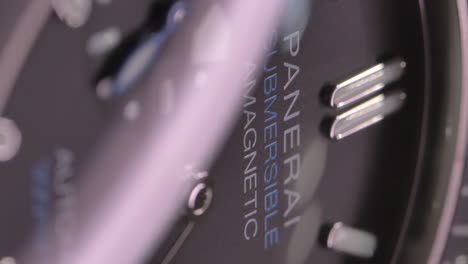 VERTICAL-Expensive-Panerai-submersible-wristwatch-with-shining-lighting-moving-across-stylish-dial-hands-close-up