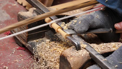 Close-Up-Feet-and-Chisel-of-Traditional-Woodworker-on-Improvised-Lathe