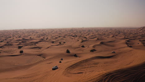 Vehicles-Speeding-Through-Vast-Desert-Landscape-On-A-Hot-Weather
