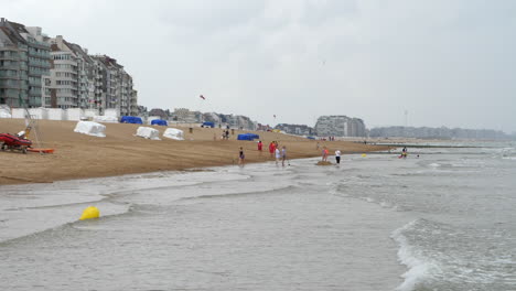 Menschen-Am-Strand-In-Knokke-Heist,-Belgien-Mit-Meereswellen-In-Zeitlupe