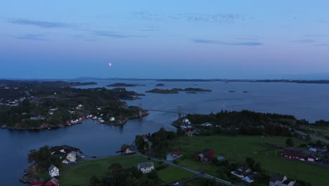 Peaceful-summer-night-on-the-idyllic-island-of-Herdla-with-full-moon-rising-over-the-ocean