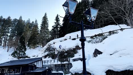 Arbeiter-Schaufeln-Schnee-In-Einem-Verschneiten-Hügel,-Ginzan-Onzen,-Japan