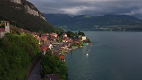 Aerial-view-flying-towards-the-town-of-Merlingen-on-Lake-Thun,-Thunersee