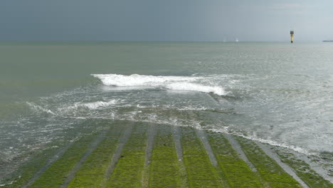 Sea-Waves-Rolling-on-Breakwater-on-a-Cloudy-Day,-Slow-Motion,-Static