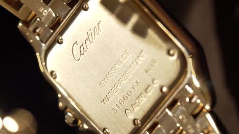 Close-up-on-luxury-gold-Cartier-jewellery-wristwatch-back-cover-detail