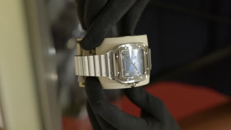 Vertikale,-Stilvolle,-Glänzende-Silberne-Cartier-Armbanduhr,-Die-Aus-Dem-Display-Des-Designer-Einzelhandelsgeschäfts-Entfernt-Und-Dem-Kunden-Gezeigt-Wird