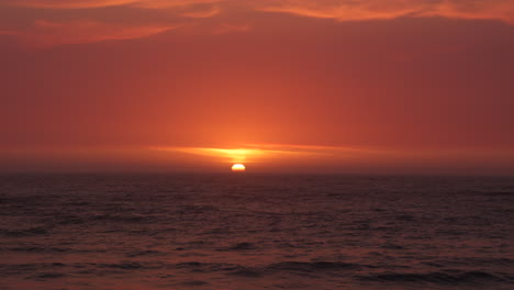 Wunderschöner-Roter-Sonnenuntergang,-Der-Den-Moment-Zeigt,-In-Dem-Die-Sonne-Im-Meer-Versinkt
