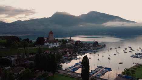 Aerial-view-approaching-the-castle-Schloss-Spiez-on-the-shore-of-lake-Thun-after-sunset