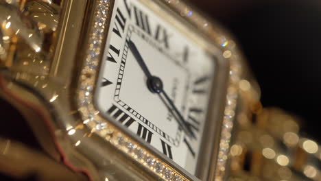 Luxuriöses,-Funkelndes-Goldenes-Cartier-Armbanduhr-Zifferblattdetail,-Das-Sich-In-Zeitlupe-Im-Licht-Dreht