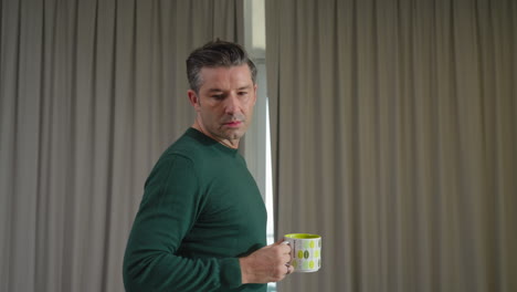 Man-Drinking-Coffee-In-Mug-While-Walking-In-The-House,-Suddenly-Stopped-Looking-Shocked-And-Turn-Back