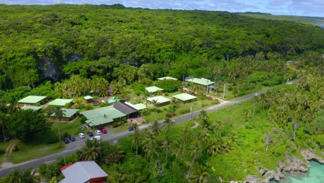 From-high-above,-the-camera-gracefully-moves-in-a-circular-motion,-showcasing-the-exclusive-Oasis-hotel,-perched-on-the-pristine-shores-of-the-remote-Lifou-island-in-New-Caledonia