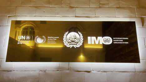 Vereinte-Nationen,-Mittelmeerkonvention,-Logos-Der-Internationalen-Seeschifffahrtsorganisation-Auf-Einer-Kalksteinmauer