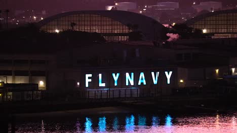 Fly-navy-sign-lit-up-at-night-with-glowing-blue-lettering