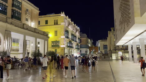 Plaza-at-the-entrance-gate-in-Valletta,-full-of-people,-at-night