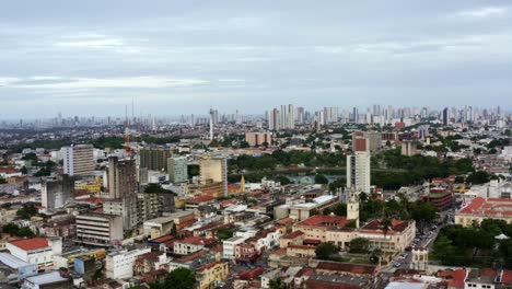 Rising-aerial-drone-shot-of-the-old-downtown-of-the-tropical-coastal-capital-city-of-Joao-Pessoa,-Paraiba,-Brazil-with-old-skyscrapers,-historic-homes,-churches-the-famous-lagoon-during-golden-hour