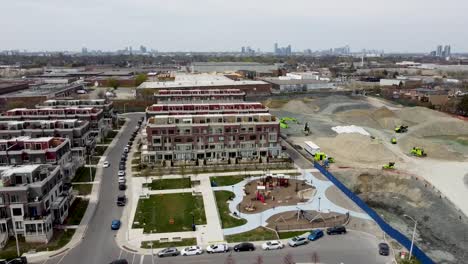 Drone-shot-circling-around-Toronto-neighborhood-with-a-playground-near-a-construction-site
