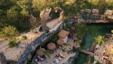 Vacation-tourist-cenote-with-hammocks-and-people-relaxing-at-casa-Tortuga,-Tulum,-Mexico