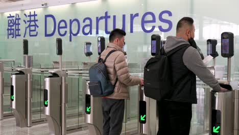 Flugpassagiere-Durchlaufen-Eine-Sicherheitskontrolle-In-Der-Abflughalle-Des-Internationalen-Flughafens-Chek-Lap-Kok-In-Hongkong