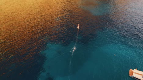 Luftaufnahme-Einer-Person,-Die-Auf-Einem-Elektrischen-Surfbrett-Entlang-Der-Küste-Spaniens-Fährt