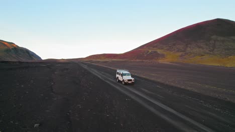 White-4X4-SUV-Driving-Through-Volcanic-Landscape-In-Iceland