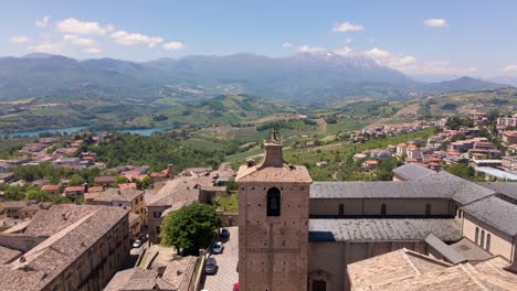 Wide-angle-drone-shot-of-an-old-church-with-a-beautiful-vista-of-mountains-in-the-distance-and-the-village-of-Chieti-in-the-region-of-Abruzzo-in-Italy