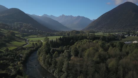Río-Cruzando-Valle-Verde-Durante-La-Temporada-De-Verano-Con-Montañas-En-El-Fondo,-Pirineos-Franceses