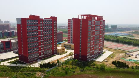 Flying-over-water-and-between-tall-buildings---Beijing-Jiaotong-University-Weihai-campus,-China